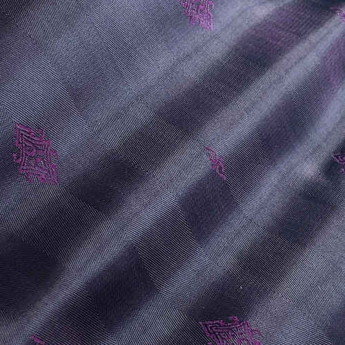 Close-up of dark blue textured fabric with small purple embroidered patterns.