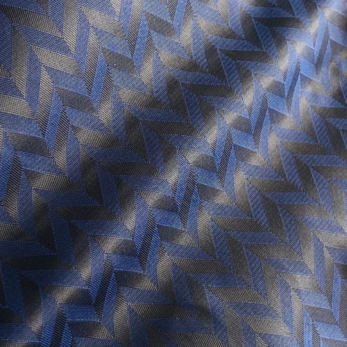 Blue and black herringbone pattern fabric with a textured, woven appearance, reflecting light subtly.