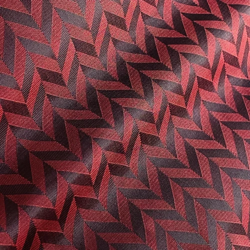 Red and black herringbone pattern fabric texture, detailed close-up view for textile design and inspiration.