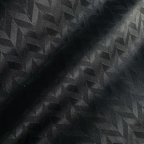 Close-up of black herringbone textured fabric, showcasing intricate weave pattern and subtle light reflection.