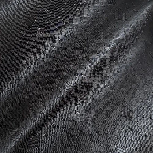 Close-up of elegant black silk fabric with subtle geometric patterns, highlighting texture and luxury feel.