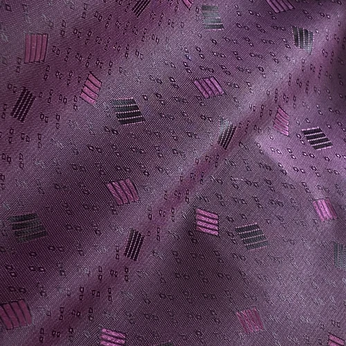 Purple patterned fabric with geometric designs and textured details, ideal for fashion or interior decoration.