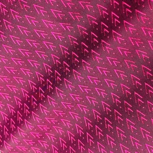 Patterned pink fabric with repeating arrow design, creating a vibrant geometric texture.