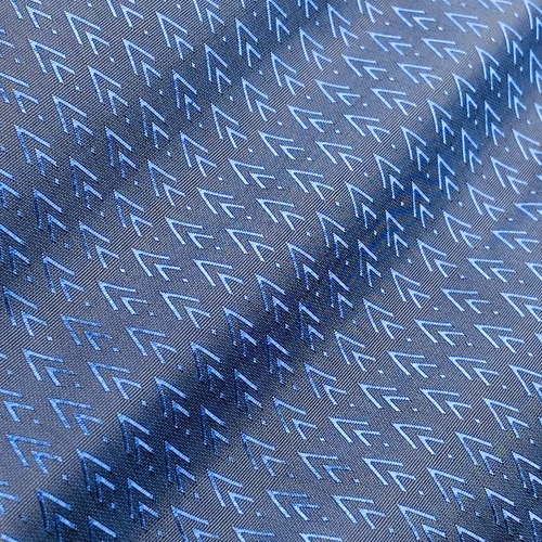 Blue and gray fabric with geometric arrow pattern, close-up texture detail for textile design inspiration.