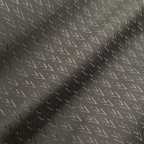 Close-up of a dark fabric with a subtle zigzag pattern, showing intricate texture and design.