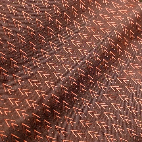 Close-up of fabric with brown geometric arrow pattern, creating a textured and modern design.