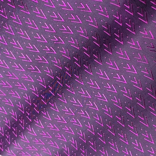 Purple fabric with a geometric arrow pattern, showcasing a sleek and modern design for stylish textiles.