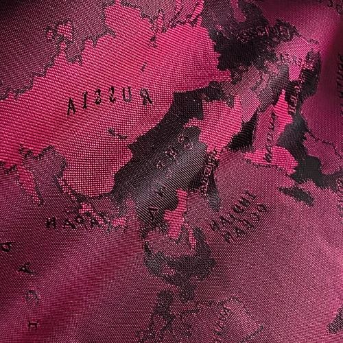 Pink world map fabric with visible black landmasses and text details, highlighting Asia and parts of Europe.