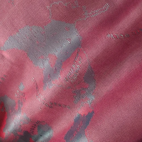 Abstract red and gray fabric texture with intricate woven design patterns.
