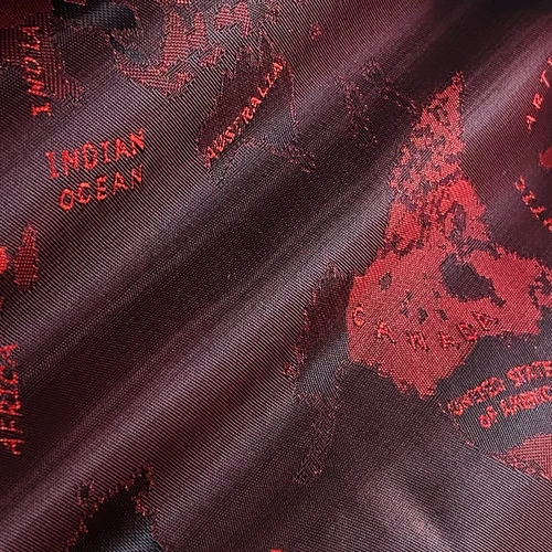 Close-up of a red and black fabric with a world map design, highlighting the Indian Ocean and Australia.