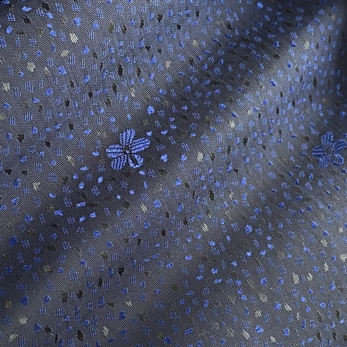 Blue floral pattern on textured dark fabric, showing intricate design details and elegant style.