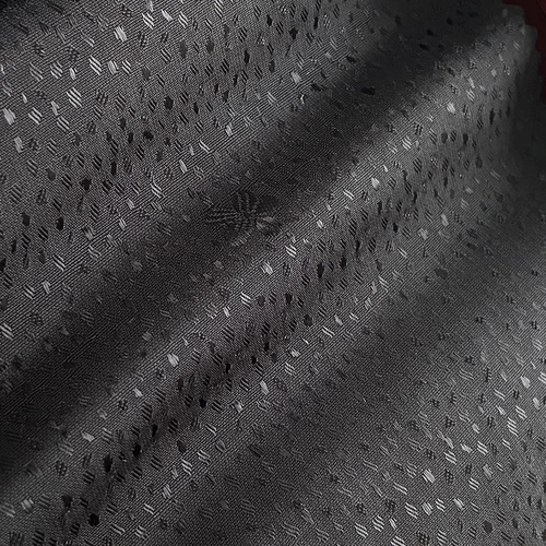 Close-up of textured dark fabric with subtle geometric patterns, creating a sophisticated and modern appearance.