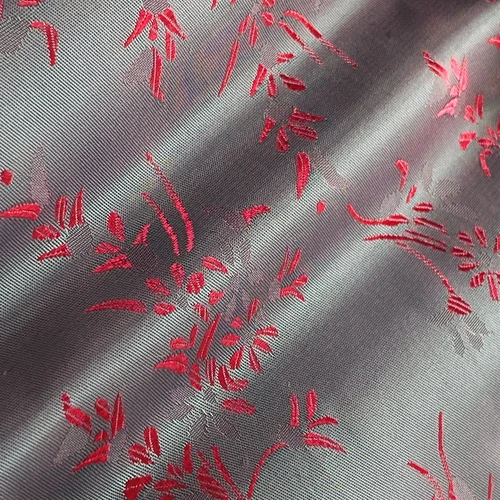 Silver and red jacquard fabric with a floral pattern, showcasing elegant texture and intricate design details.