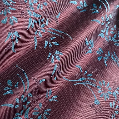 Elegant purple silk fabric with intricate blue floral embroidery design.