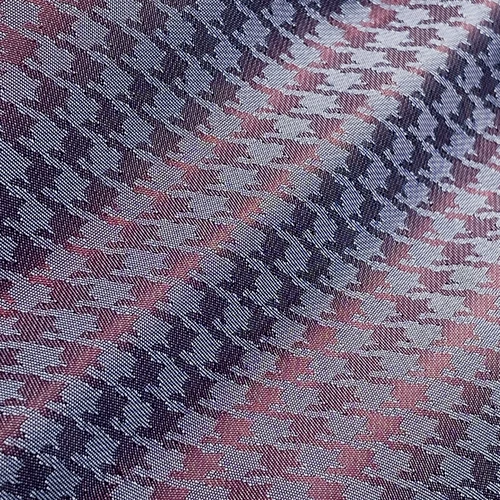 Houndstooth pattern fabric in purple and white, close-up view showing texture and repeat design.