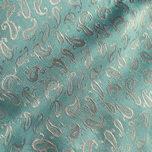 Teal fabric with silver paisley pattern, close-up view showcasing intricate textile design.