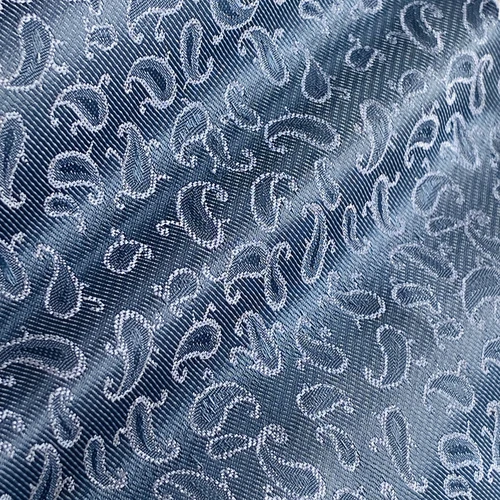 Close-up of a blue paisley fabric pattern with intricate designs and subtle texture.