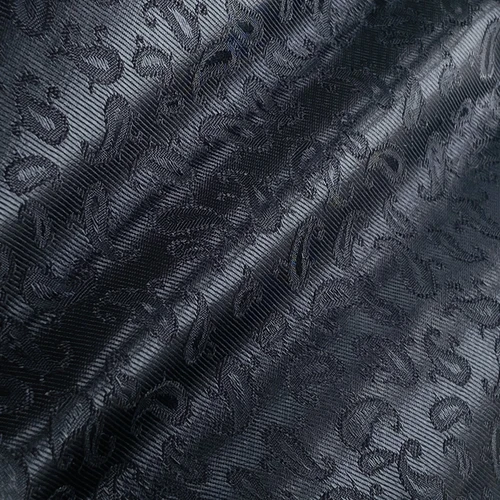 Close-up of dark blue jacquard fabric with intricate floral patterns, highlighting texture and elegant design.