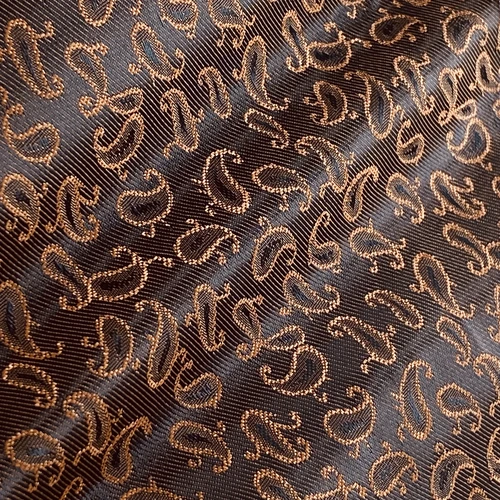 Brown fabric with a detailed paisley pattern, featuring elegant gold embroidery for a luxurious appearance.