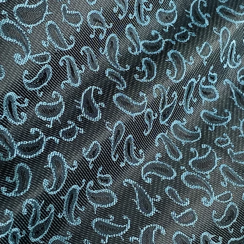 Elegant paisley pattern on fabric with a black and blue design, perfect for fashion or interior decor themes.