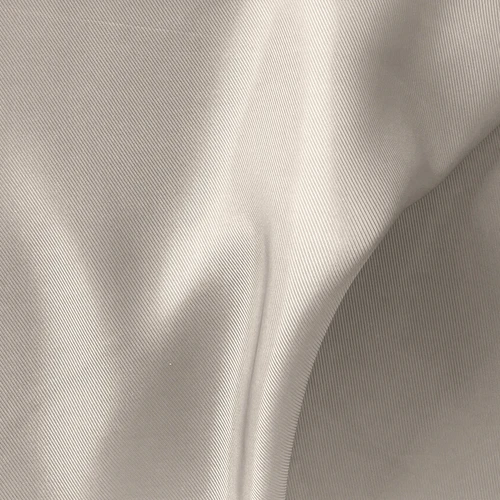 Close-up of smooth, beige, satin-like fabric, showcasing fine texture and subtle shine, ideal for luxury clothing or decor.