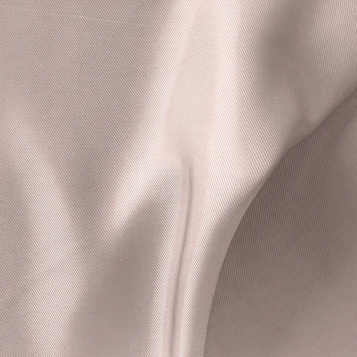 Close-up of beige fabric with a smooth, textured surface, showcasing elegant folds and subtle sheen in natural light.
