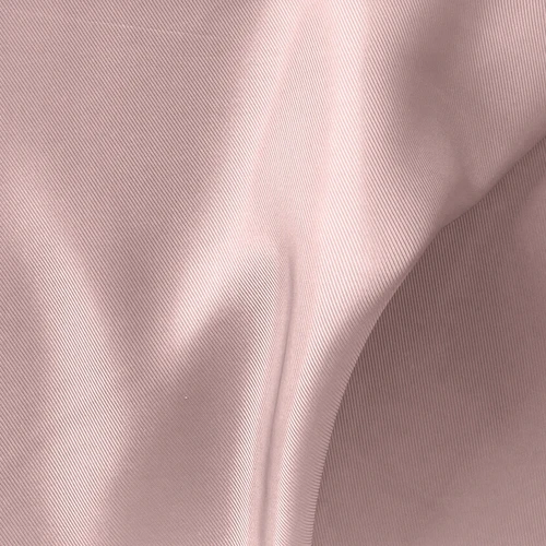 Close-up of soft pink fabric with subtle folds and diagonal lines, showcasing texture and gentle color tones.