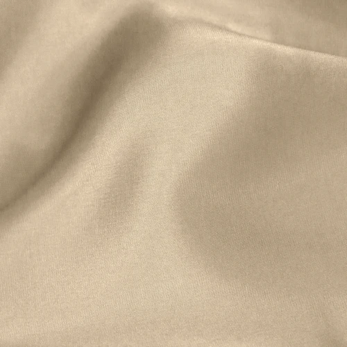 Smooth beige fabric with gentle folds, creating a soft and elegant texture ideal for fashion or home decor.