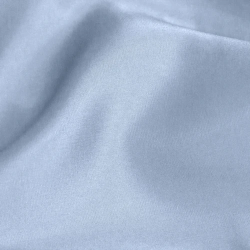 Soft, smooth pale blue fabric close-up, showing fine texture and gentle folds, ideal for textiles and fashion designs.