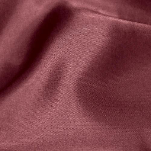 Smooth maroon fabric with soft folds, showcasing a silky texture for luxury clothing or interior design.