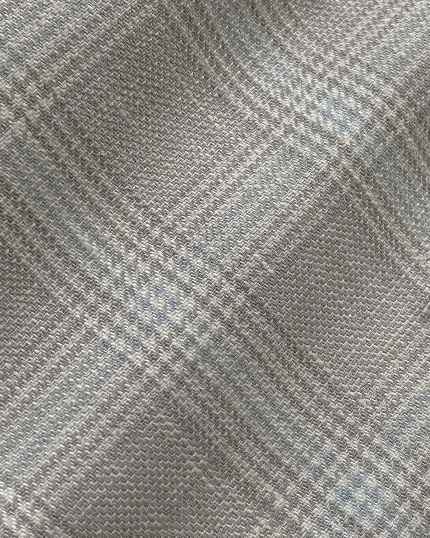 Close-up of gray and blue checkered fabric texture, showcasing woven pattern details.