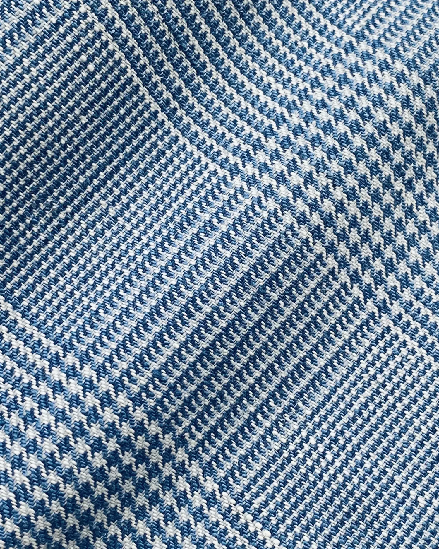 Close-up of textured blue and white houndstooth fabric pattern.