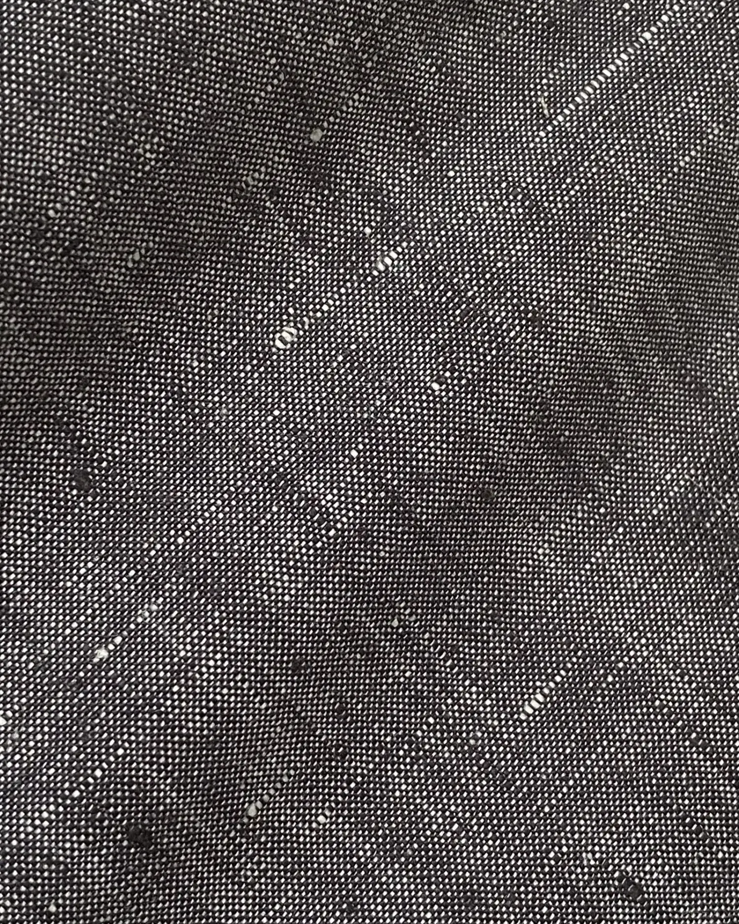 Close-up of black tweed fabric texture with subtle white specks, perfect for fashion or interior design inspiration.
