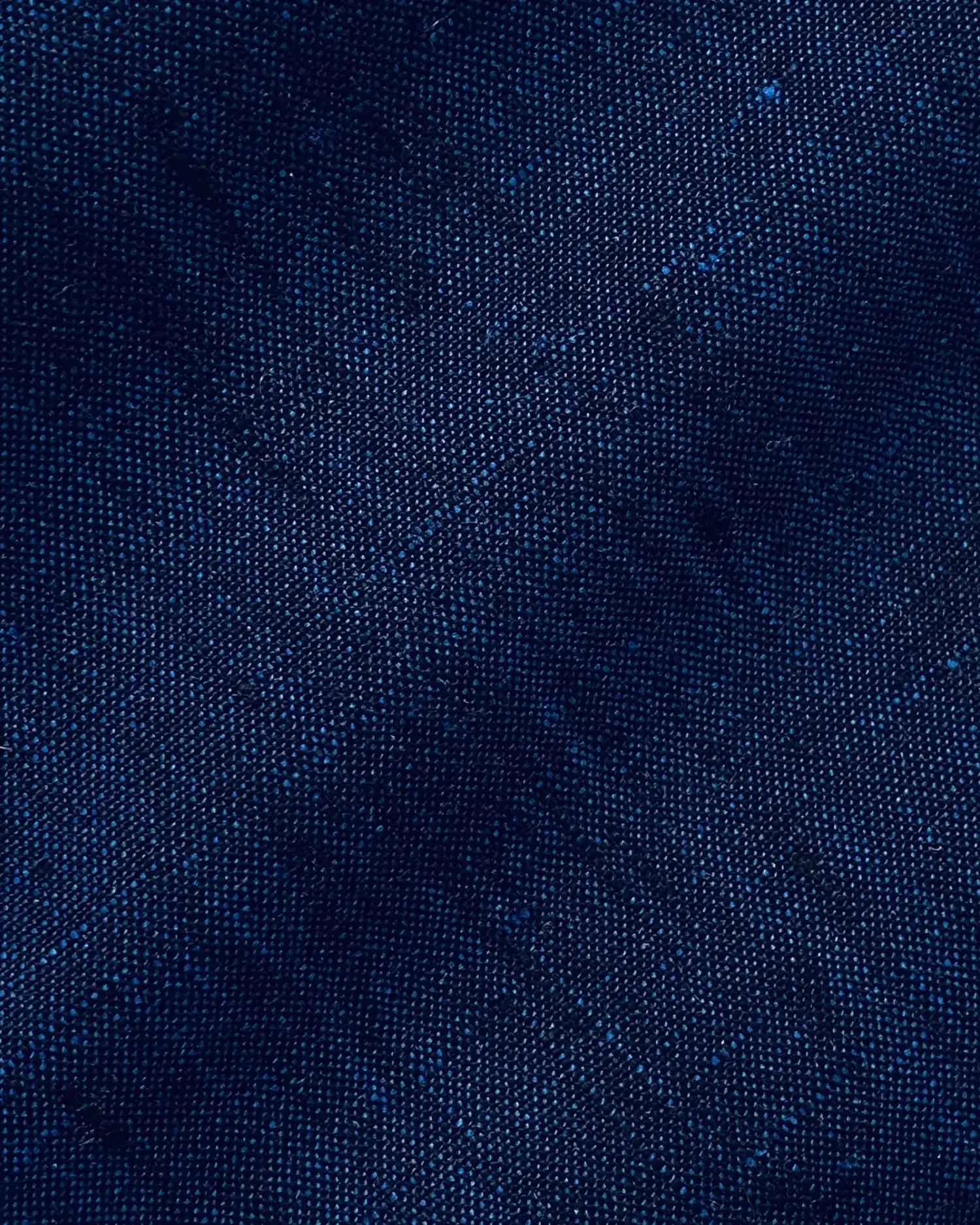 Close-up of textured dark blue fabric with a subtle weave pattern.