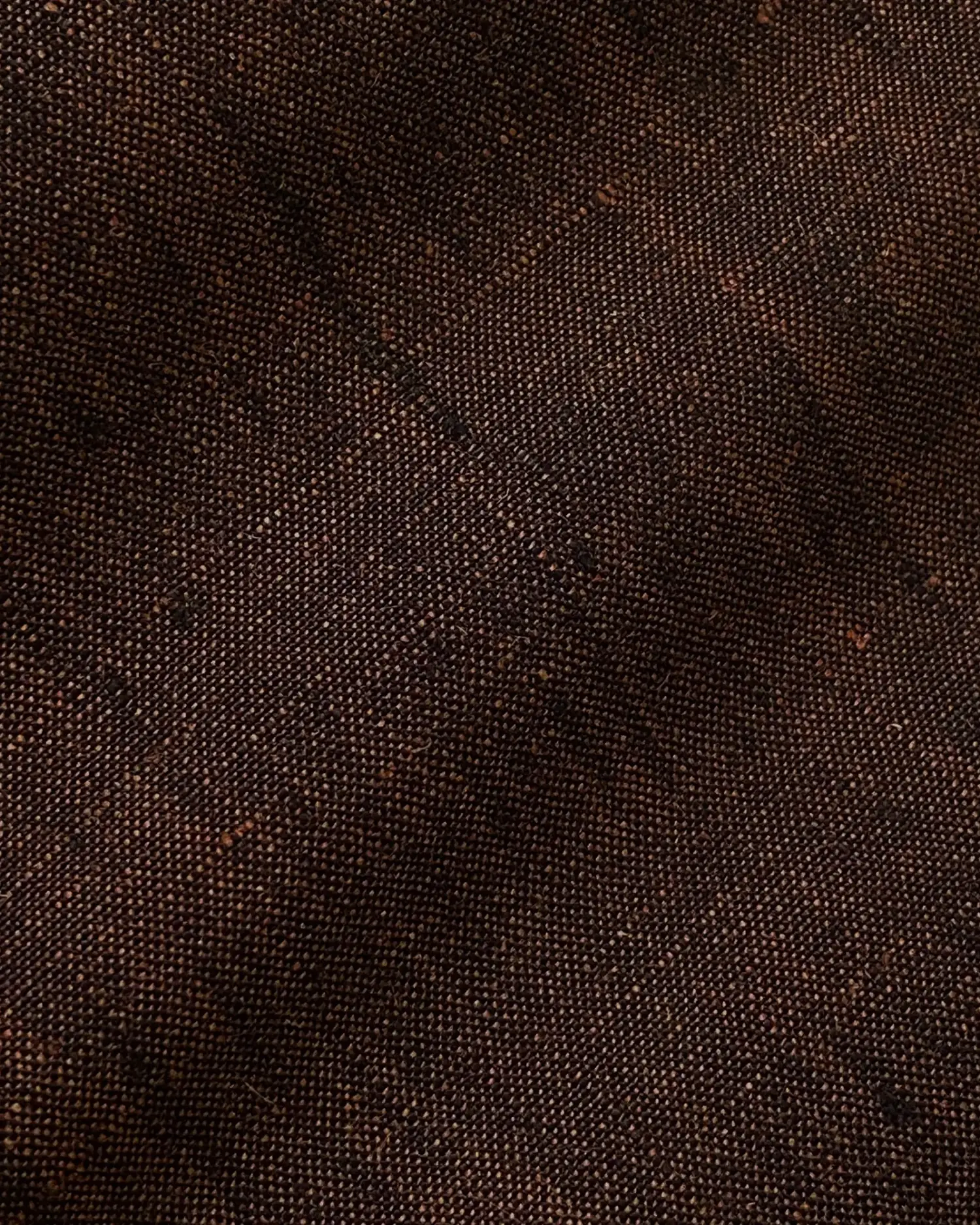 Close-up of dark brown textured fabric with a detailed woven pattern.