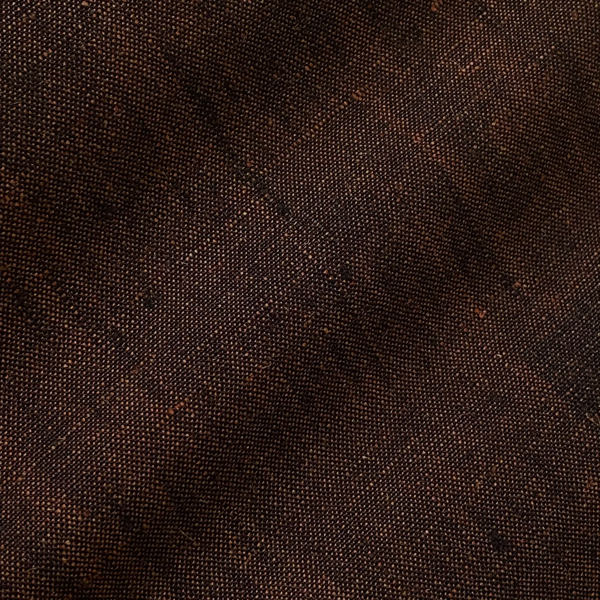 Close-up of dark brown textured fabric with a detailed woven pattern.