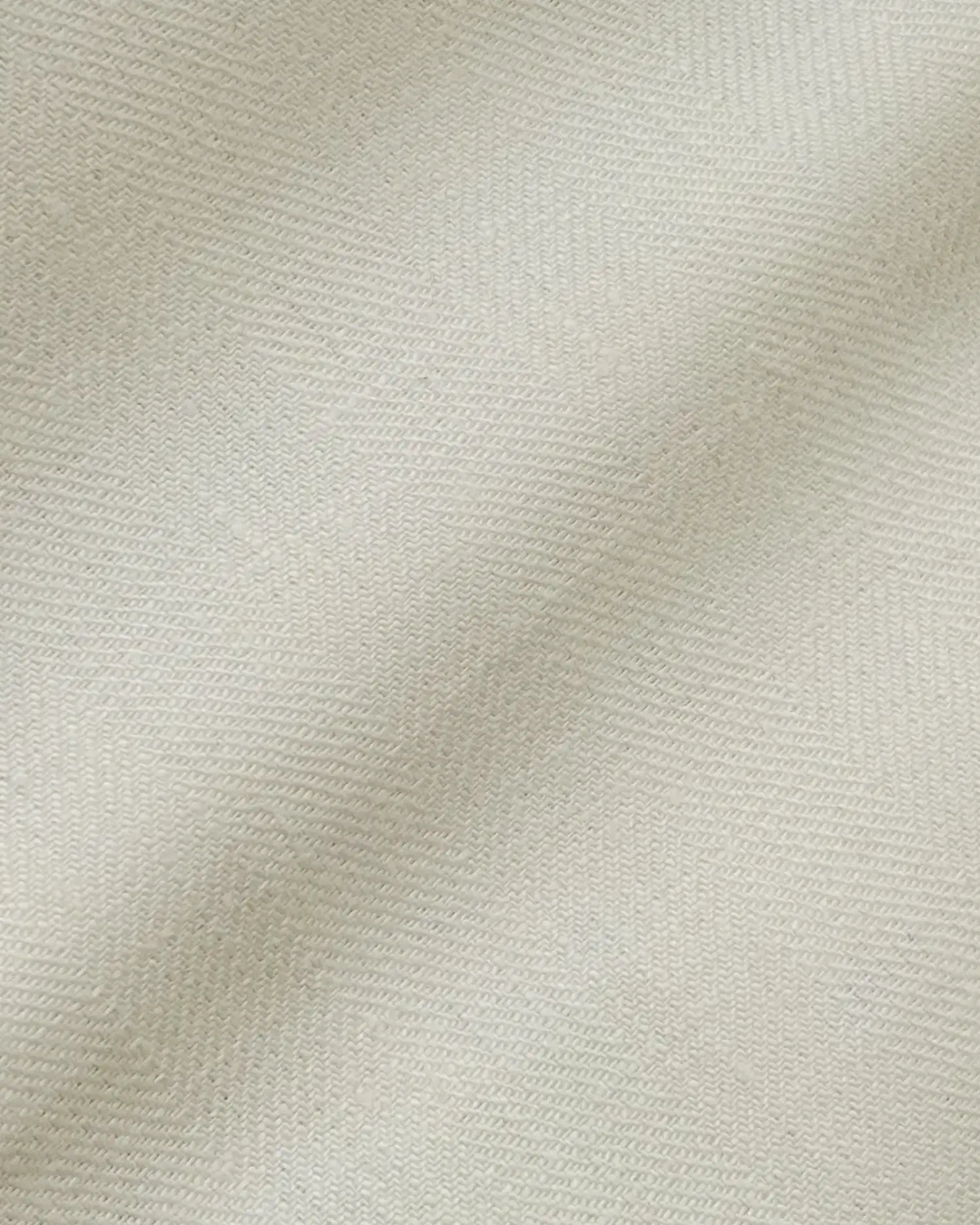 Close-up of cream herringbone fabric texture, showcasing detailed woven pattern for textiles and upholstery design.