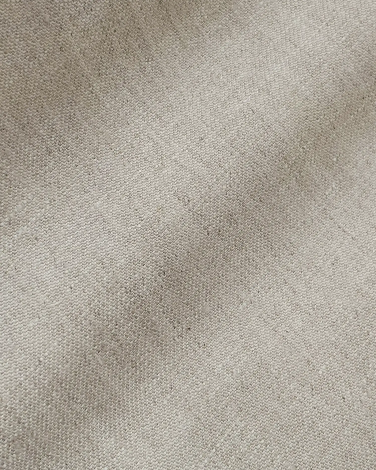 Close-up of beige textured fabric, showcasing fine woven details and a smooth surface, ideal for upholstery.