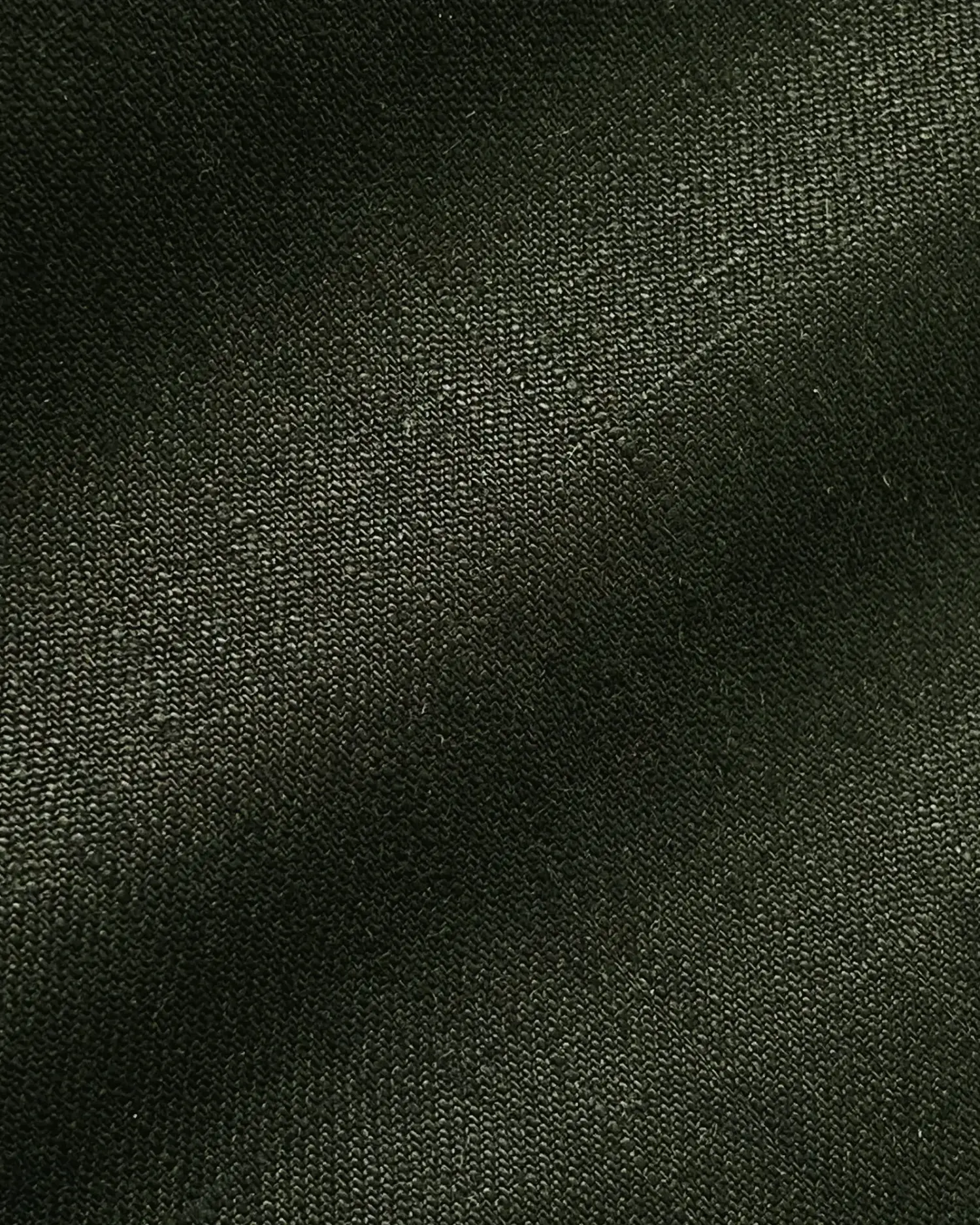 Close-up of dark green textured fabric with visible weave pattern.