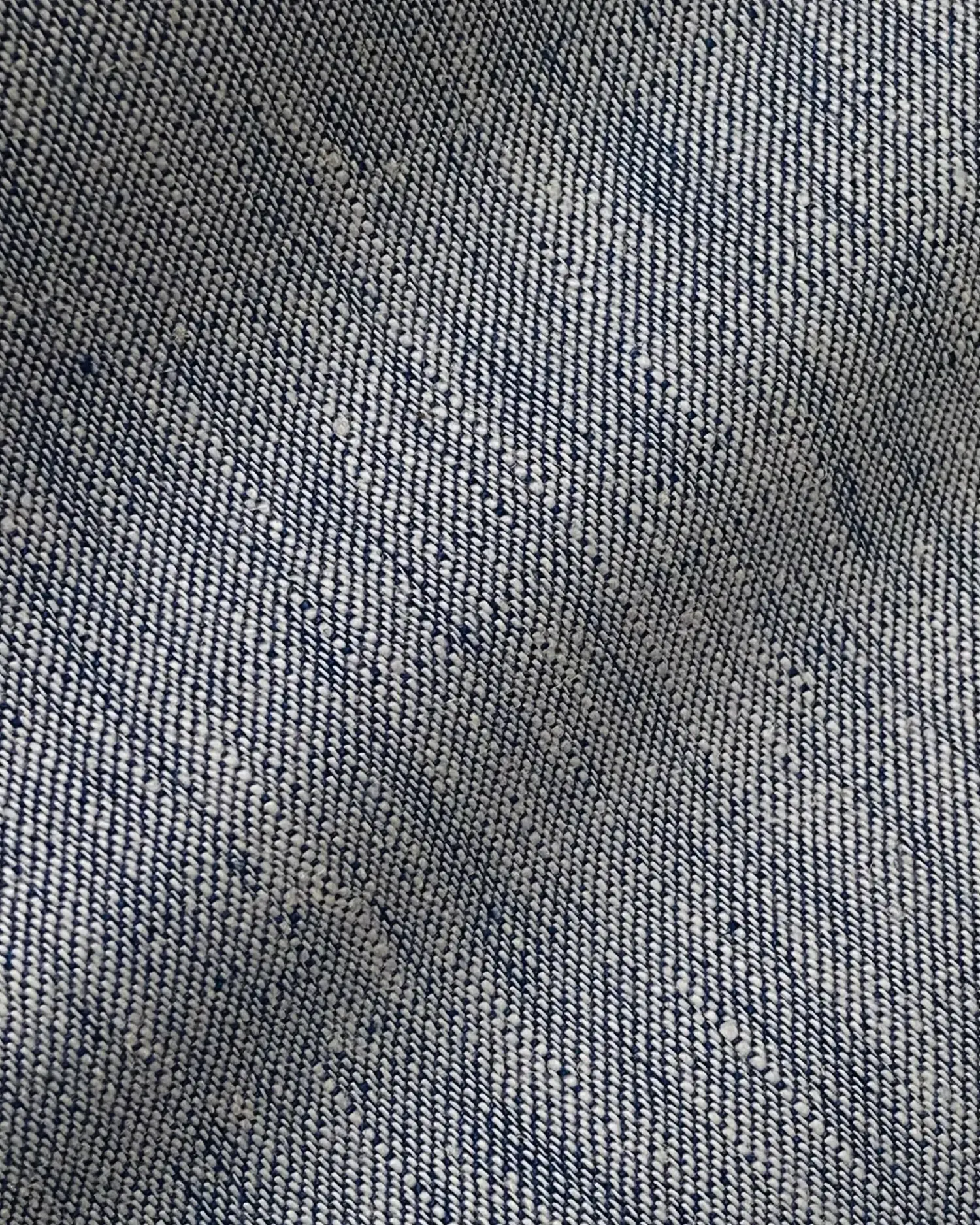 Close-up of blue and white denim fabric texture, showcasing diagonal weave pattern.